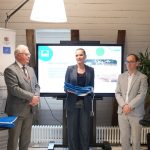 Zilais karogs Daugavgrīvas peldvietā Rīgā, tīra pludmale ar sakoptu infrastruktūru, kas atbilst starptautiskajiem vides kvalitātes standartiem un nodrošina drošu atpūtu pie ūdens.