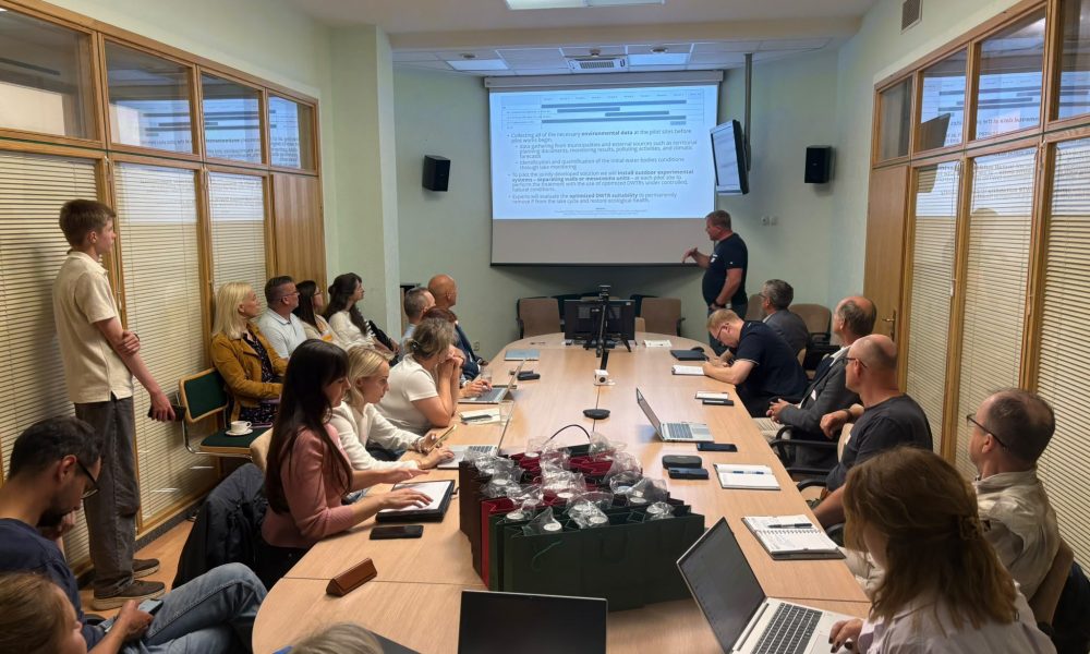 RE-FRESH projekta partneri un eksperti projekta sanāksmē apspriež pētījumu rezultātus, ezeru atjaunošanas metodes un turpmākās aktivitātes. RE-FRESH projekta partneru un ekspertu sanāksme konferenču telpā. Attēlā redzami dalībnieki pie sanāksmju galda, prezentācija uz ekrāna un klēpjdatori darba procesā. RE-FRESH ezeru atjaunošanas projekts veicina pārrobežu sadarbību ūdenstilpju kvalitātes uzlabošanai.